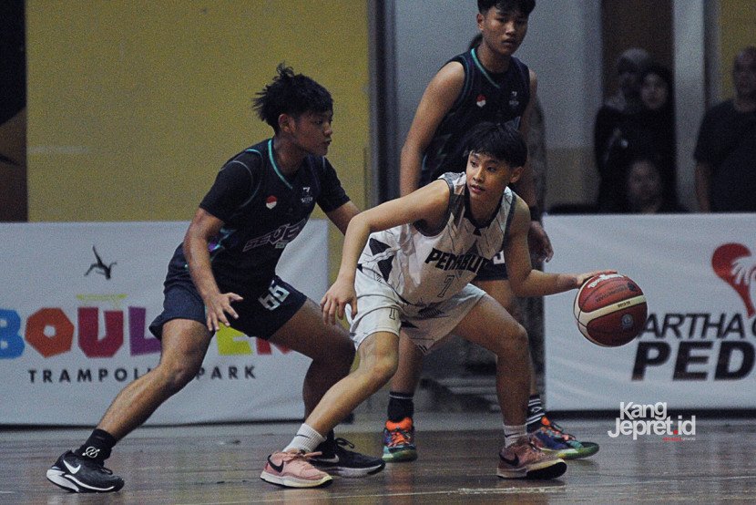 Forward Tim BPK Penabur Benencio Gesten Fernando dibayangi SMPN 7 Bandung Rizqi Aditya Adriansyah pada laga Grup O Revival Basketball Championship di GOR Pajajaran, Bandung, Ahad (7/9/2025). (KANGJEPRET.ID/ YOGI ARDHI) (Data: Nikon D3, Nikkor AF 80-200/2.8 ED 3rd Gen)